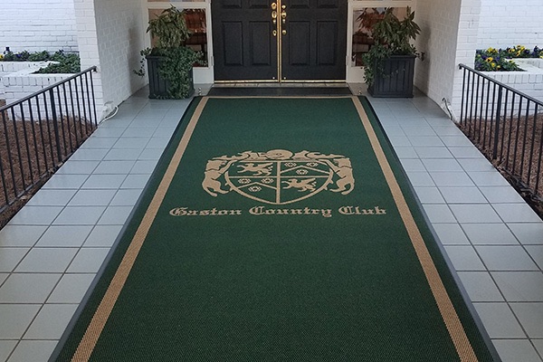 Custom green crest logo runner at a country club entrance
