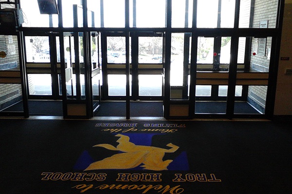 Custom welcome logo mat at a high school entrance