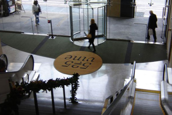 Circular-door logo mat at an office building entrance